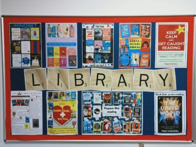 Noticeboard with posters showing library books and newsletter.